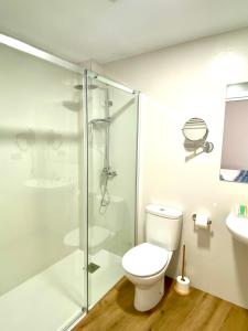 a bathroom with a toilet and a glass shower at El Rincón de Serradilla in Serradilla