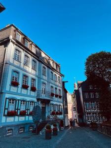ein blaues Gebäude in einer Straße mit Menschen davor in der Unterkunft LandschaftsTräume in Simmerath