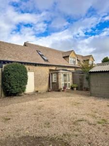 a large brick house with a large yard at Cosy flat in Ampney Crucis in Ampney Crucis