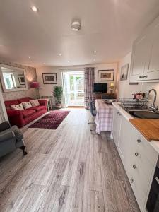 a living room with a kitchen and a living room with a couch at Cosy flat in Ampney Crucis in Ampney Crucis