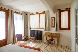 a bedroom with a desk and a table and chairs at Bell Plançó B&B in Moià