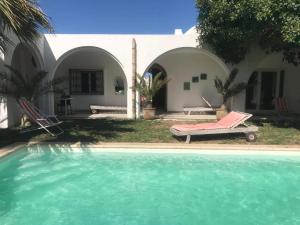 a swimming pool in front of a house at Esmeralda in Djerba