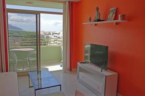 a living room with a tv and a table and a window at Puerto Naos Apartment in Puerto Naos