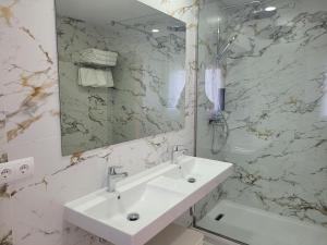 a white bathroom with a sink and a mirror at Hotel Rural Can Maries in Puerto de San Miguel
