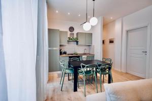 a kitchen and dining room with a black table and chairs at Politeama Charming Apartment in Palermo