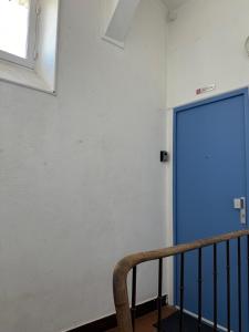 a blue door in a room with a staircase at Le Studio Bellifontain in Fontainebleau