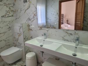 a bathroom with a sink and a toilet and a mirror at Hotel Rural Can Maries in Puerto de San Miguel