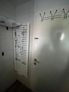 a bathroom with a white door and a rack on the wall at Schöne EG Wohnung in Kolbermoor