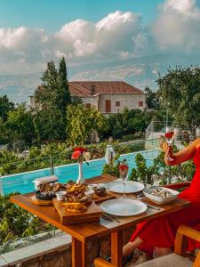 a woman sitting at a table with wine glasses at KCOR Hotels in Ḩārat at Taḩtā