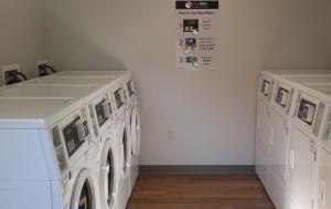twee witte wasmachines in een wasruimte bij Affordable Suites of America Portage in Portage