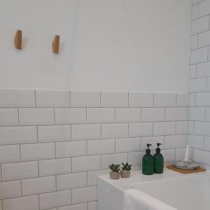 two green bottles sitting on a counter in a bathroom at The Studio a super cute place nr Southwold in Southwold