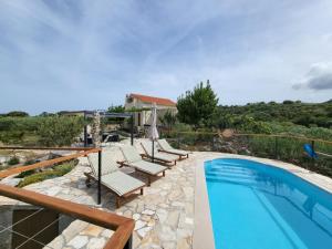 a villa with a swimming pool and a house at Robinson crusoe style house "MASLINA'' in Škrip