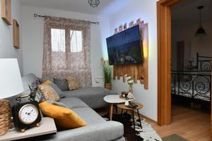 a living room with a couch and a clock on a table at Robinson crusoe style house "MASLINA'' in Škrip