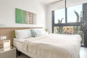 a white bedroom with a large bed and a window at LMS48- Roof terrace, jacuzzi & sauna in Estepona +75 photos