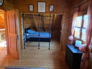 Cette chambre comprend un lit dans une cabane en bois. dans l'établissement Großes gemütliches Chalet im Steigerwald nähe Bamberg, à Lisberg