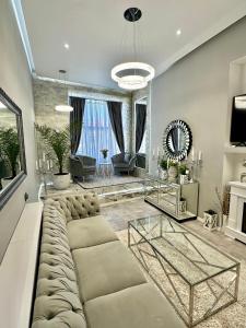 a living room with a large couch and a table at DeyInn Guest House Centrum in Turda