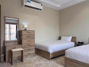 メディナにあるطيبة للشقق الفاخرةTaiba Luxury Apartments of 3 Bedrooms 5 minutes to Haramのベッドルーム1室(ベッド2台、鏡付きドレッサー付)