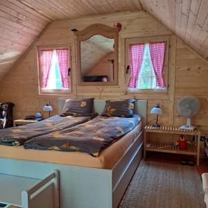 Un dormitorio con una cama en una cabaña de troncos en Vile Bliznakinje, en Vinci