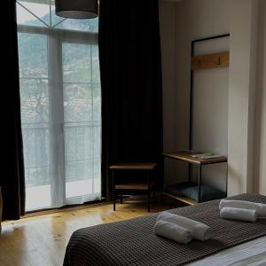 a bedroom with a bed and a large window at Boutique hotel mestia in Mestia