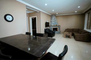 a living room with a table and a fireplace at Kottage ji in Bakuriani