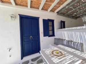 a blue door on a white wall with a bench at Blue Pearl Maisonette in Ornos