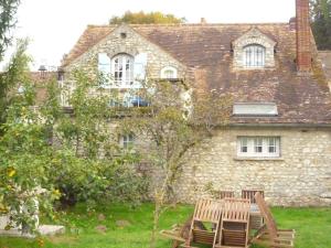 an old stone house with two chairs in front of it at Gite du Moulin des Noues in Saint-Germain-sur-École