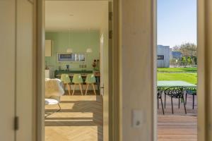 a view of a kitchen and a living room with a table at Klein Goud - Ecohuisjes Terschelling in Midsland