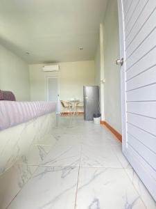 a room with a white tile floor and a table at บ้านพรธรณีรีสอร์ทเขาใหญ่บ้านสไตล์นอร์ดิก-Baan Ponthoranee Resort Khao Yai in Ban Khlong Yang