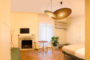a bedroom with a bed and a table and a fireplace at Casaretti Affittacamere - In centro a Foligno, con parcheggio e ampio bagno in camera in Foligno