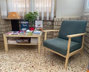 a desk and a chair and a table with books at Hostal Moreno in Silla