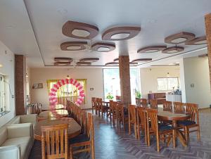a dining room with wooden tables and chairs at Mangalam Palace in Seonī +19 photos
