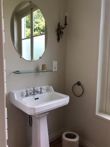 Un baño con un lavabo blanco y un espejo. en Château de Luzières, en Conty