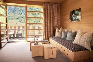 salon z kanapą i dużym oknem w obiekcie abitare chalets w mieście Obergurgl