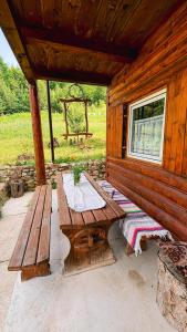 a wooden cabin with a picnic table and a bench at Cabana Trei Brazi Cacica in Cacica +39 photos