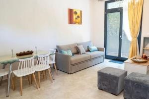 a living room with a couch and a table and chairs at Chios Kampos Apartments in Varvásion