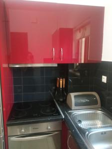 a kitchen with red cabinets and a stove and a sink at Rosemary Grand View in Exopoli +29 photos