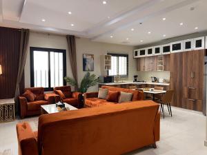 メディナにあるطيبة للشقق الفاخرةTaiba Luxury Apartments of 3 Bedrooms 5 minutes to Haramのリビングルーム(オレンジ色の家具付)、キッチン