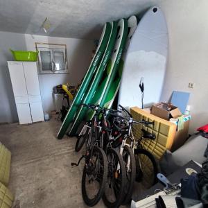 a room with bikes and surfboards on the wall at Vila PURA MAYA in Vir