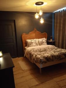 sypialnia z łóżkiem z drewnianym zagłówkiem w obiekcie Escapade romantique dans une demeure du 18ème w mieście Buchères +11 zdjęć