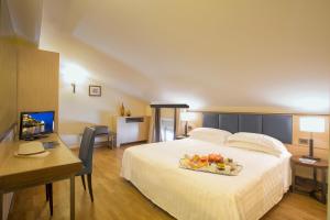a hotel room with a bed with a tray of fruit on it at Virgilio Grand Hotel in Sperlonga