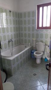 Un baño con bañera y WC. en Casa di Enea, en Durrës