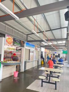 a food court with tables and people in a restaurant at Beach side Cozy Bungalow in Tanjung Bungah