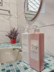 a bottle of soap on a bathroom counter next to a sink at Beach side Cozy Bungalow in Tanjung Bungah