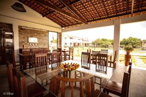 a dining room with a glass table and chairs at Villaz Lençóis Maranhenses in Santo Amaro