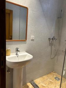 a bathroom with a sink and a shower with a mirror at Cozy corner in Kigali +8 photos