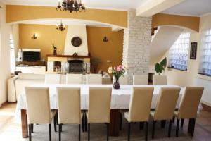 a dining room with a white table and chairs at Pension Casa Ali & Andu in Buşteni