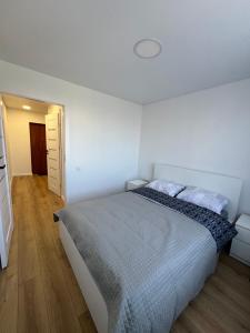 a bedroom with a large bed in a white room at Modern&bright southwest apartment in Šiauliai