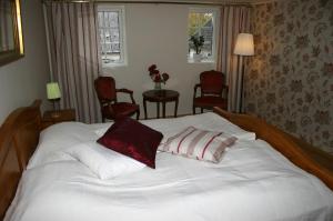 Un dormitorio con una cama blanca con dos almohadas encima. en Lyckegården, en Munka-Ljungby 6 fotos más