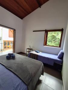 a bedroom with two beds and a window at Casa Papa-Vento Pousada in Lençóis