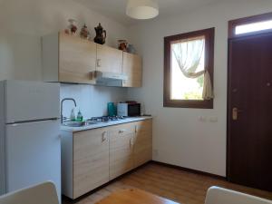 a kitchen with wooden cabinets and a white refrigerator at appartamento Modì in Pistoia